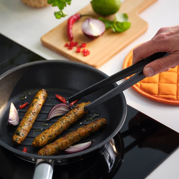 Worstjes koken met groenten in een pan