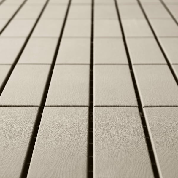 Lichtgrijze vloerpanelen zijn gelijkmatig gerangschikt en hebben een gladde, weerbestendige kunststof textuur.