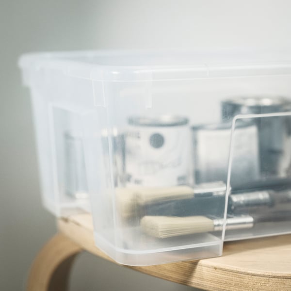 Doorzichtige plastic opslagbak met organiseringsgereedschap op een houten plank.
