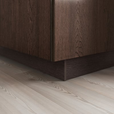Donkerhouten kast met strakke, zwarte plintonderstel, wat een moderne uitstraling geeft.