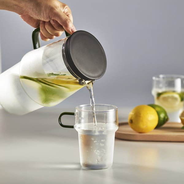 Kankan in glas gieten; Zeefdeksel houdt ijs in de kan.