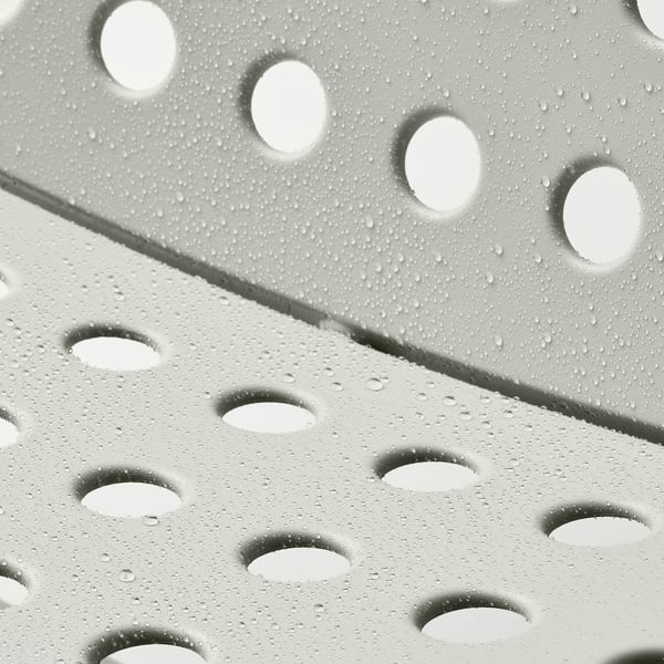 Metalen tuinstoel met geperforeerde zitting en waterdruppels, ontworpen voor comfort en duurzaamheid.