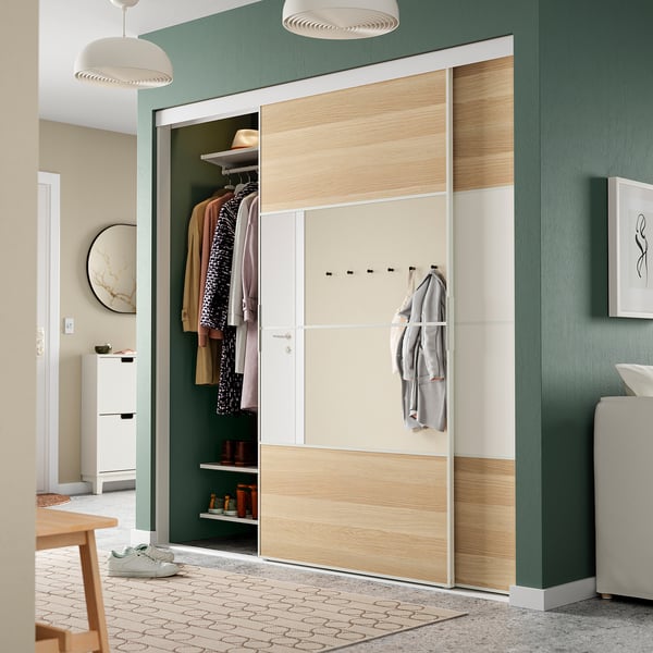Moderne groene kamer met open kast, kleding, planken, haken en hanglampen.