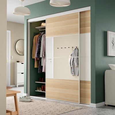 Moderne groene kamer met open kast, kleding, planken, haken en hanglampen.