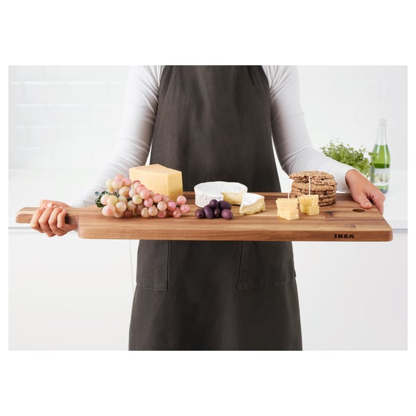 Persoon met houten snijplank met kaas, druiven en crackers, geschikt voor het serveren en vriendelijk voor messen.