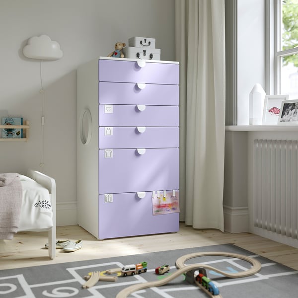 Kinderslaapkamer met SMÅSTAD lavendel, kist met 6 lades. Lang, past in de buurt van een wit bed. Houdt kleding & speelgoed vast. Kunststof handgrepen, houten vloer.