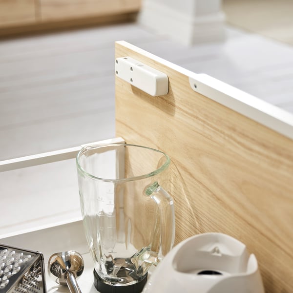 Houten snijplank met een doorzichtige blender waar witte tags aan bevestigd zijn.
