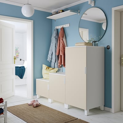 Moderne entree: blauwe muren, wit meubilair, ronde spiegel, kast met spiegelblad & geel kussen.