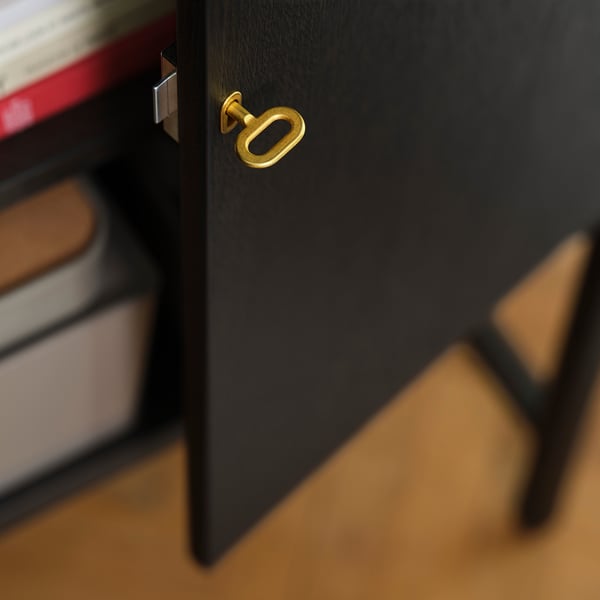 Zwarte kast met gouden handgreep, met hoogwaardige afwerking en design.