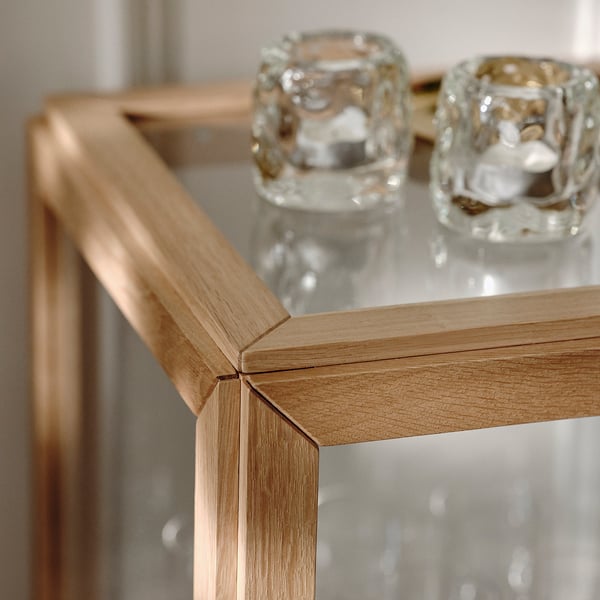 Close-up van een glazen kast met eikenhouten frame, met fijn vakmanschap en stevige verbindingen.