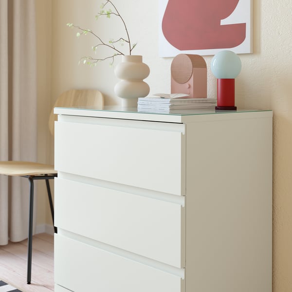 Moderne kist met glazen bovenkant ter bescherming, met decoratie en foto's.