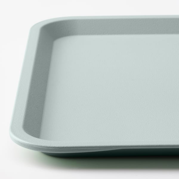 Lichtblauw plastic dienblad met glad oppervlak, schuine randen, geplaatst op witte achtergrond.
