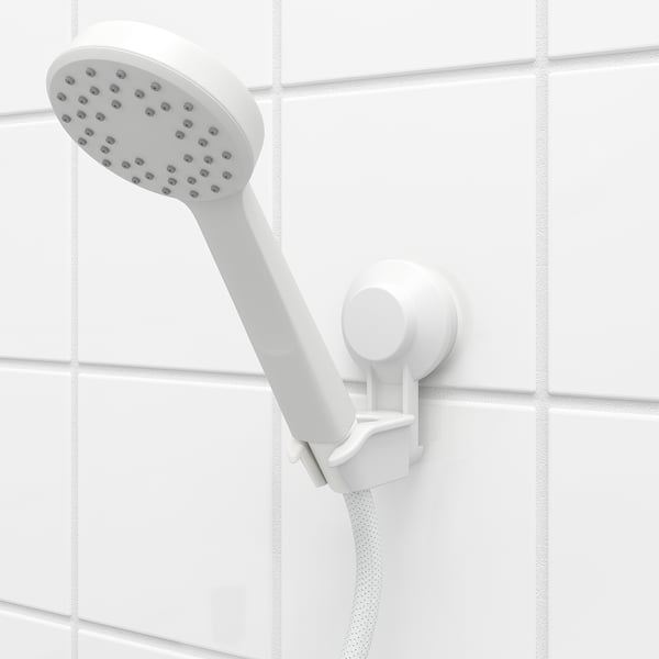 Witte douchekop op houder, naar beneden gekanteld, zuignap gemonteerd op betegelde wand, eenvoudig te bevestigen en te verwijderen.