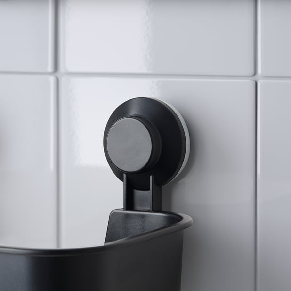 Zwarte TISKEN badkamertafel met ronde zuigkracht, houdt shampoo stevig vast.