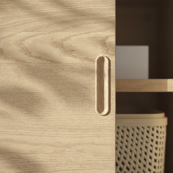 Licht houten kastdeur met strakke, moderne handgreep. De afwerking van geborsteld fineer geeft een elegante, unieke textuur.