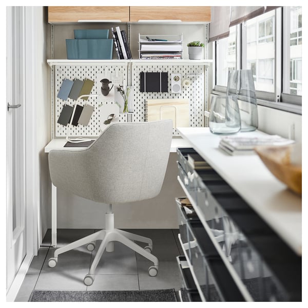 Modern minimalistisch thuiskantoor met witte TOSSBERG-stoel, ophangbord en bureau bij raam.