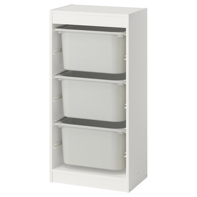 Een witte TROFAST opbergunit met drie uitneembare grijze bakken voor het organiseren van spullen.