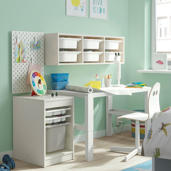 Studieruimte voor kinderen met witte TROFAST-opslag, ophangbord en bureau. Lichte, georganiseerde ruimte met kleurrijke benodigdheden.