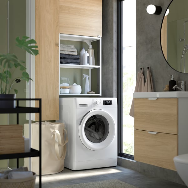 Moderne wasruimte met witte wasmachine, beukenhouten kast en glazen deur.