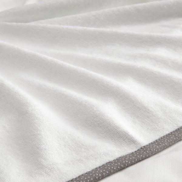 Close-up van zachte, witte, badstof baby verschoonmat hoes, met gladde stof en stevige omzoomde rand.