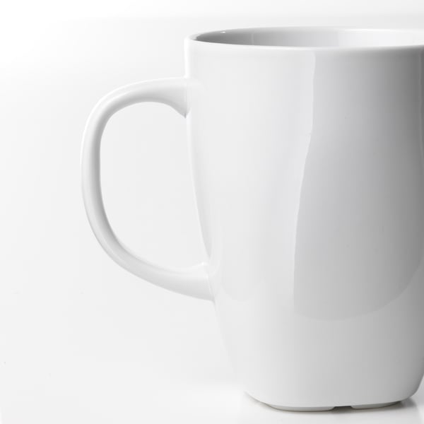 Glanzende witte mok met stevig handvat op witte achtergrond.