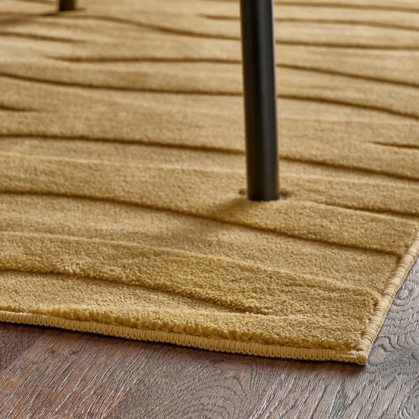 Laagvaand, geelbruin tapijt met golvend 3D-patroon, ontworpen voor eenvoudig onderhoud en antislip onderkant.