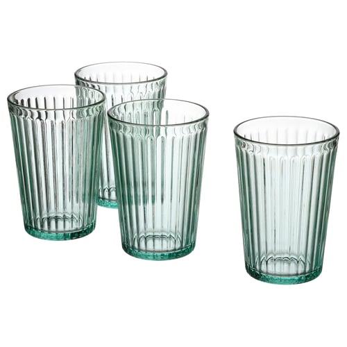 Vier heldergroen getinte, gecanneleerde glazen bekers met grote voetstukken en smalle randen, gerangschikt in een lijn. Gemaakt van gehard glas.