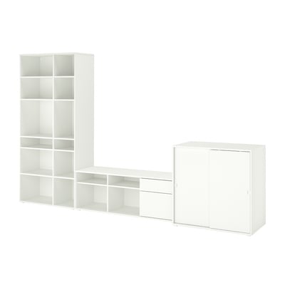 Een witte VIHALS opbergset, inclusief een hoge plank, een breed tv-meubel en een kast met schuifdeuren, ideaal voor het indelen van woonruimtes.