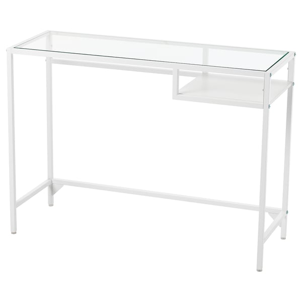 De VITTSJÖ tafel heeft een wit metalen frame, een glazen blad en een kleine glazen plank. Het moderne ontwerp is strak en minimalistisch.