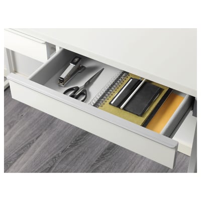Open white desk drawer showing organised office supplies.