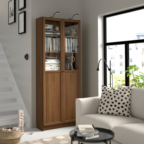Modern living room with BILLY bookcase, white sofa, black floor lamp, and window.
