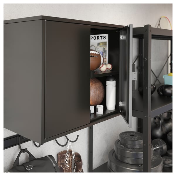 Black metal storage cabinet with shelves holding sports equipment.