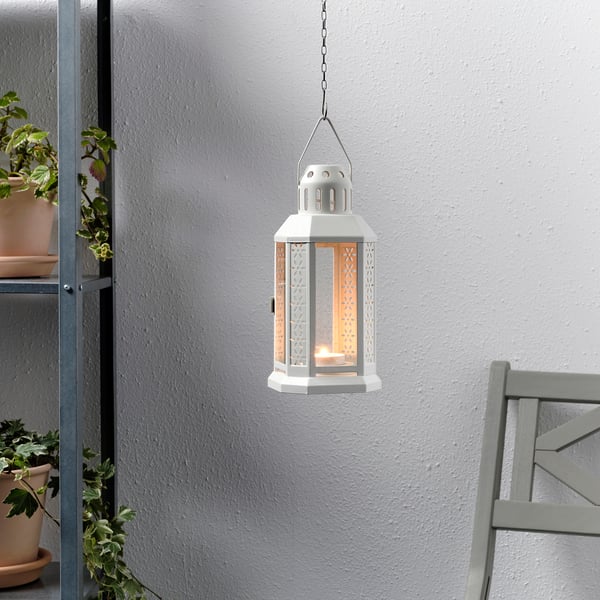 Hanging lantern with warm glow, illuminated by tealight, suitable for indoor/outdoor use.