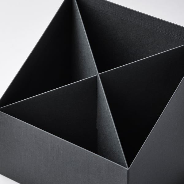 Black four-compartment paperboard desk organiser, neatly assembled, viewed from above.