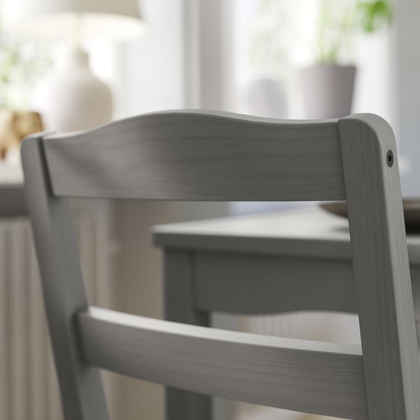 Dark grey wooden chair close-up, sleek design with curved backrest.