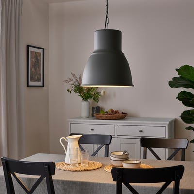 Cosy dining area with HEKTAR pendant light, rustic table, chairs, and flowers.