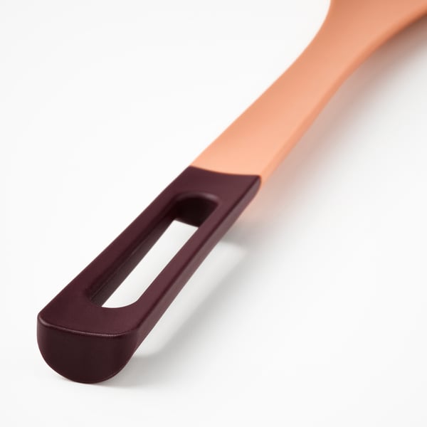 Close-up of a modern, colourful cooking spoon with ergonomic handle and silicone tip.