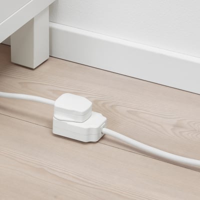White extension cord on wooden floor, connected to wall.