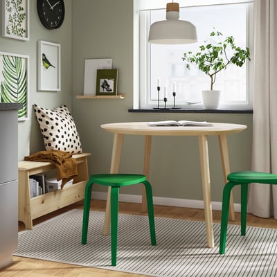 Small green KYRRE stool by light wood table, gentle modern decor.