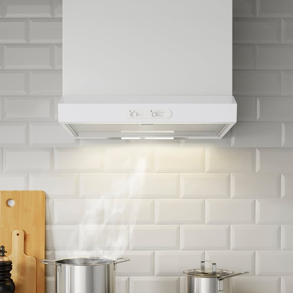 A white kitchen hood with led light and controls mounted above a tiled backsplash. Below it, there are cooking pots.