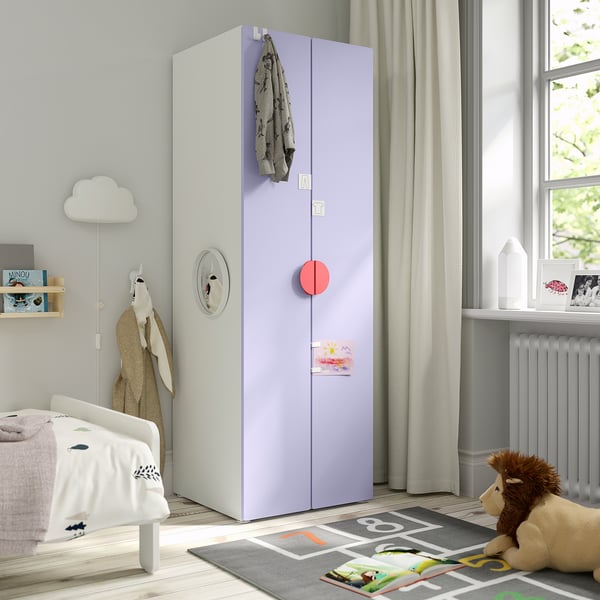 A childs room with a tall SMÅSTAD wardrobe, sweater, teddy bear, and books.
