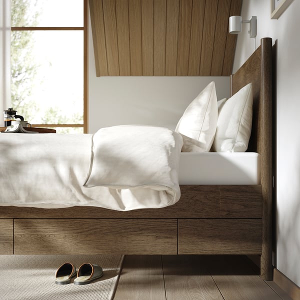 Bedroom featuring TONSTAD bed with drawers, slatted base, and wall lamp.