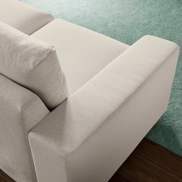 A modern, light-colored sofa section with plush cushions, resting on a soft blue rug, showcasing comfortable and high-quality design.