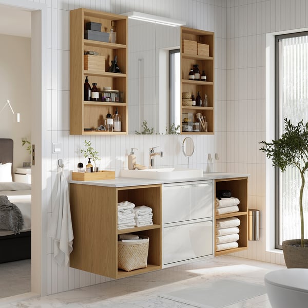 White ÄNGSJÖN bathroom vanity with wood, marble, open/closed storage, semi-recessed basin, towels.