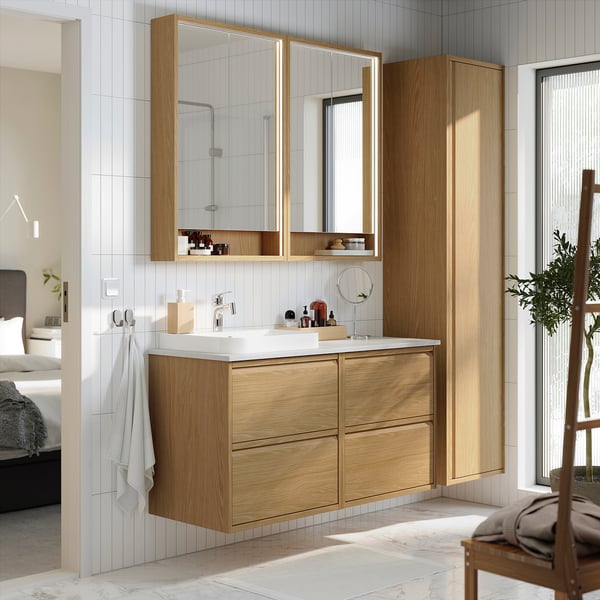 Modern oak bathroom vanity with marble sink, mirrors, and drawers.