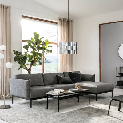 Modern living room with ÄPPLARYD grey sofa, black coffee table, large window, hanging lamp, plant, and rug.