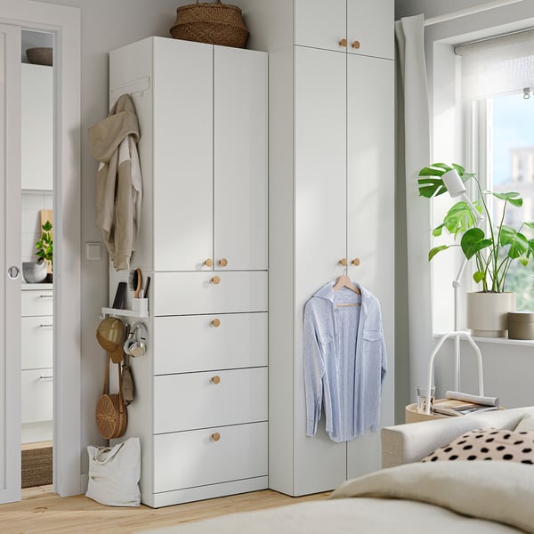 Minimalist bedroom with white ALTARLIDEN hook rack, wardrobe, window plant, and polka-dot pillow.