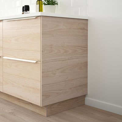 Wooden kitchen cabinet with ash-grain pattern and sleek handles.