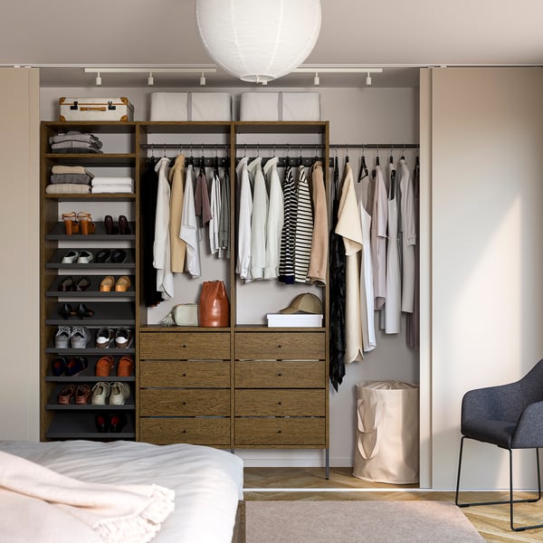 AURDAL wooden closet, well-organized with hanging clothes, shoes, and drawers. Modern minimalist design, fitting neatly in a room with a chair.