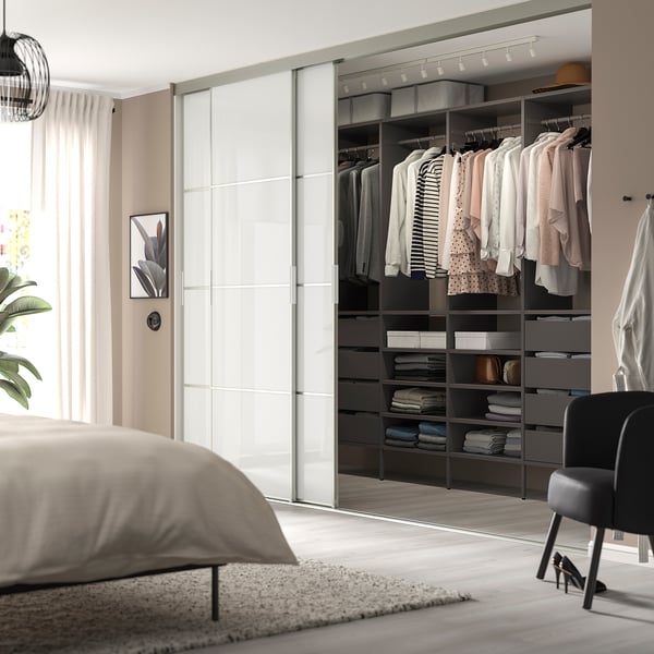 Bedroom with large open closet, AURDAL system. Clothes and items neatly organised. Advanced sliding door. Modern, light design.